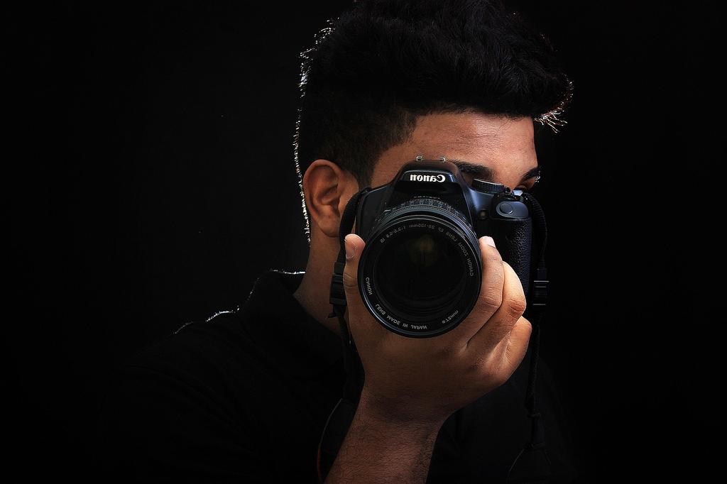 Professional photographer Sarah Chen holding a camera in her studio